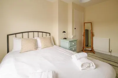 a bedroom with a white bed with towels on it at 41 Eastward Ho in Leiston