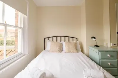 a bedroom with a bed with white sheets and a window at 41 Eastward Ho in Leiston