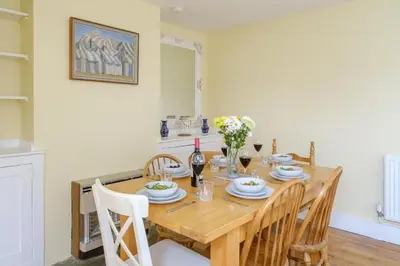 a dining room with a wooden table and chairs at 41 Eastward Ho in Leiston