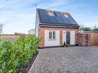 a house with solar panels on the roof at Rose Cottage in Peldon