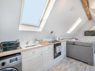 a kitchen with a sink and a couch in a room at Rose Cottage in Peldon
