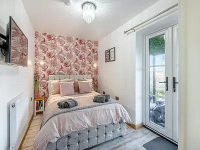 a bedroom with a large bed and a window at Rose Cottage in Peldon