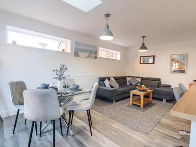 a living room with a table and a couch at Little Haven in Frinton-on-Sea