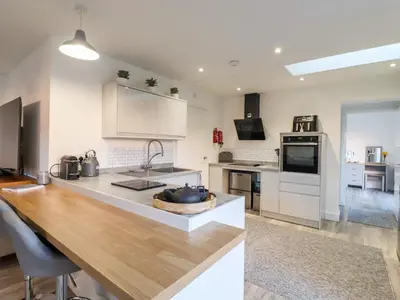 a kitchen with white cabinets and a wooden counter top at Little Haven in Frinton-on-Sea