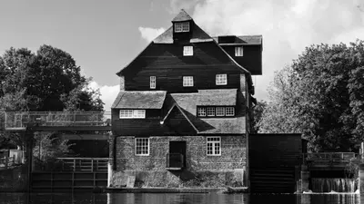 an old house in the water with a bridge at Superb 4BD Stay in Wyton and Houghton Village in Wyton