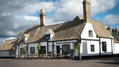 a white building with tables and chairs in front of it at Superb 4BD Stay in Wyton and Houghton Village in Wyton
