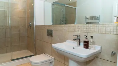 a bathroom with a sink and a toilet and a shower at Superb 4BD Stay in Wyton and Houghton Village in Wyton