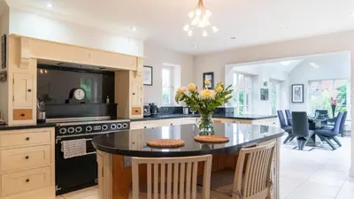 a kitchen with a center island with a vase of flowers at Superb 4BD Stay in Wyton and Houghton Village in Wyton