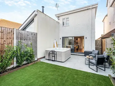 a backyard with a hot tub and a lawn at Coastal Gem in Clacton-on-Sea