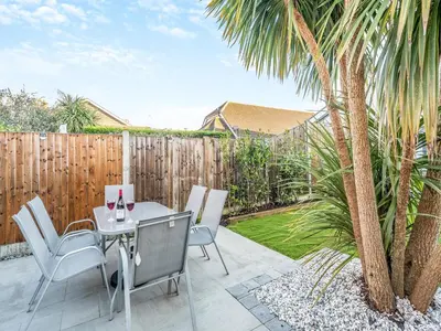 a patio with a table and chairs and a fence at Coastal Gem in Clacton-on-Sea