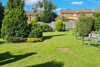 a lawn with tables and chairs in a yard at 1 Bed Sleeps 2 with Private Garden in Harlow