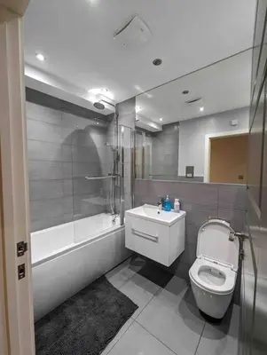 a bathroom with a toilet and a shower and a sink at Elegant Central Brentwood Flat in Brentwood