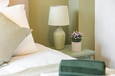 a bed with a lamp on a table with flowers at Chelmsford Centre View Sleep 4 Next Chelmer canal in Chelmsford
