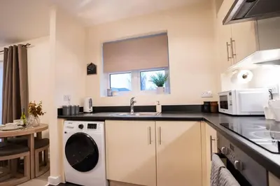 a kitchen with a sink and a washing machine at Cosy 2 Bedroom flat in Stevenage in Stevenage