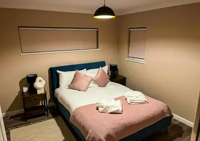 a bedroom with a bed with two towels on it at Stylish & Modern Apartment - Southend Stays in Southend-on-Sea