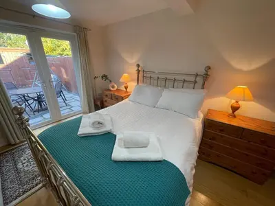 a bedroom with a bed with two towels on it at Cosy Country Hideaway opposite Three Horseshoes Pub in Madingley village in Madingley