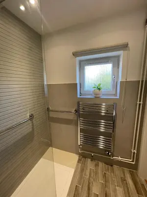a bathroom with a shower and a window at Cosy Country Hideaway opposite Three Horseshoes Pub in Madingley village in Madingley