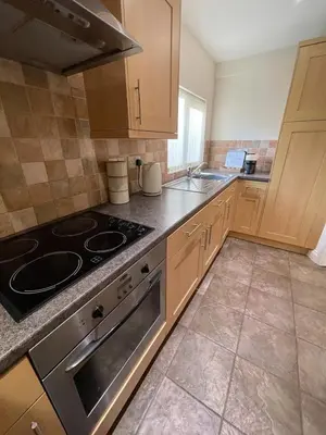 a kitchen with a stove and a sink at Cosy Country Hideaway opposite Three Horseshoes Pub in Madingley village in Madingley