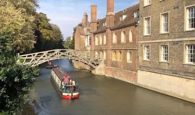 a boat traveling down a river under a bridge at Cambridge Narrowboats - Beautiful Narrowboat Glyndwr in Cambridge