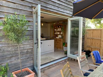 a kitchen with a sliding glass door on a patio at Lodge Cottage in Harwich