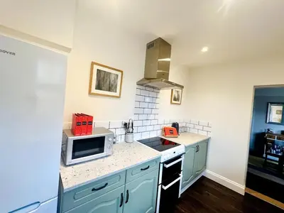 a kitchen with blue cabinets and a microwave at Countryside Cottage By Walks & Coast, With Parking in Manningtree