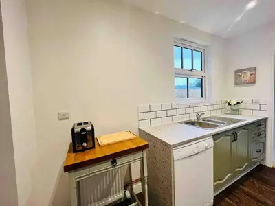 a small kitchen with a sink and a counter at Countryside Cottage By Walks & Coast, With Parking in Manningtree