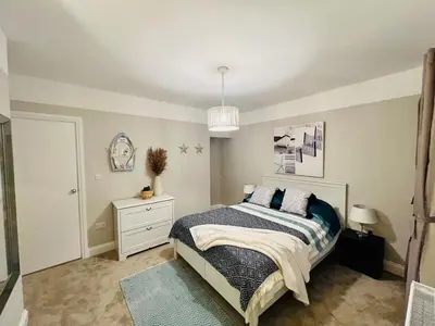 a bedroom with a bed and a pendant light at Countryside Cottage By Walks & Coast, With Parking in Manningtree