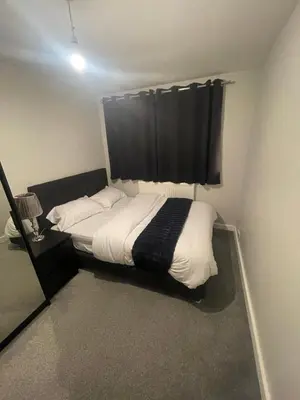 a bedroom with a bed with a black curtain at Beautiful en-suite bedroom in Ipswich