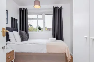 a bedroom with a bed and a window at 4 Bedroom House with Parking & Garden by Cherry Inn Short Let's & Services Accomodation in Cambridge