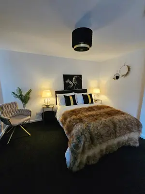 a bedroom with a large bed and a cat laying on the floor at Deluxe Town Centre Studio Stevenage in Stevenage