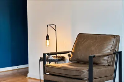 a brown leather chair in a room with a lamp at Stylish City Centre Apartment with Free Parking, Fast W-fi, Smart TV and Balcony by Yoko Property in Chelmsford