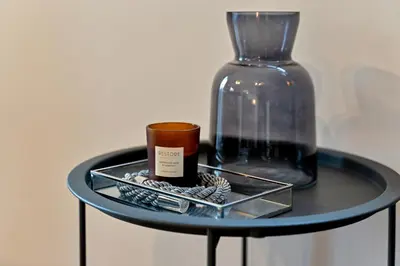 a table with a glass bottle and a cup on it at Stylish City Centre Apartment with Free Parking, Fast W-fi, Smart TV and Balcony by Yoko Property in Chelmsford