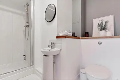 a bathroom with a sink and a toilet and a mirror at Stylish City Centre Apartment with Free Parking, Fast W-fi, Smart TV and Balcony by Yoko Property in Chelmsford