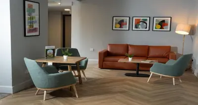 a living room with a couch and a table and chairs at Cambridge Bar Hill Hotel, BW Signature Collection in Cambridge