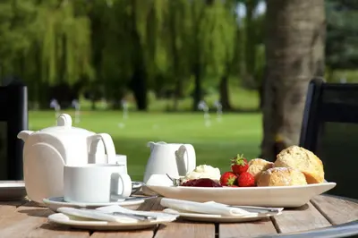 a table with a plate of food and a plate of strawberries at Cambridge Bar Hill Hotel, BW Signature Collection in Cambridge