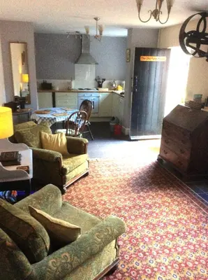 a living room with couches and a living room with a kitchen at The Old Pump House in Bungay
