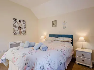 a bedroom with a bed with a blue headboard at 2 Bed in Norwich oc-64075 in East Harling
