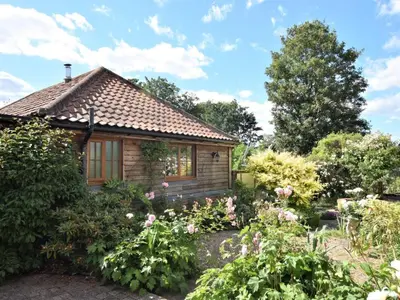 a cottage in the garden with flowers at 2 Bed in Norwich oc-64075 in East Harling
