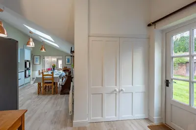 a room with a white door and a dining room at The Pottage in Hoxne