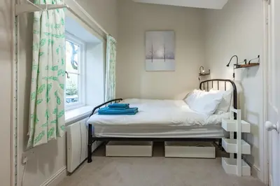 a small bedroom with a bed and a window at The Pottage in Hoxne