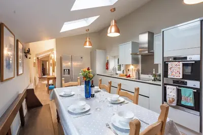 a kitchen and dining room with a table and chairs at The Pottage in Hoxne