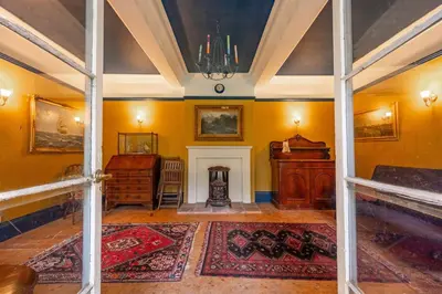 a living room with yellow walls and a fireplace at The Pottage in Hoxne