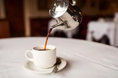 a person pouring coffee into a cup on a table at The Orwell Hotel in Felixstowe