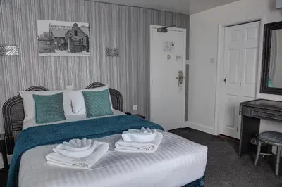 a bedroom with a bed with towels on it at The Orwell Hotel in Felixstowe