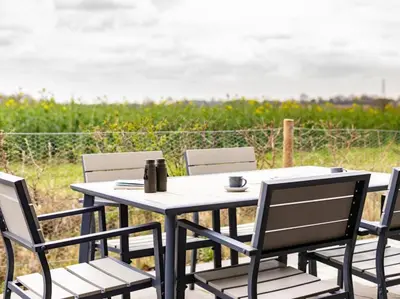 a table and chairs with the ocean in the background at 2 Bed in Diss oc-51468 in Wortham