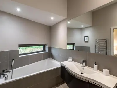 a bathroom with a tub and a sink and a mirror at 2 Bed in Diss oc-51468 in Wortham