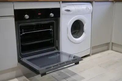 an open oven in a kitchen with a washing machine at The Butcher's Block in Puckeridge