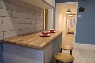 a kitchen counter with two cups and two stools at The Butcher's Block in Puckeridge