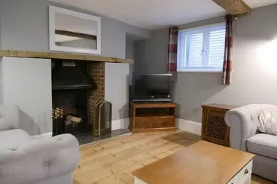 a living room with a fireplace and a tv at The Butcher's Block in Puckeridge