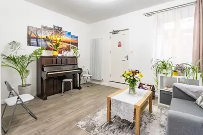 a living room with a piano and a couch at Prestige Guest House Cambridge Modern Ensuite Rooms in Cambridge